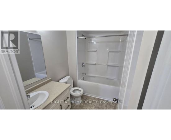 A bathroom with a toilet, sink, and shower.