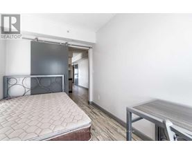 A bedroom with a bed, a table and a chair.