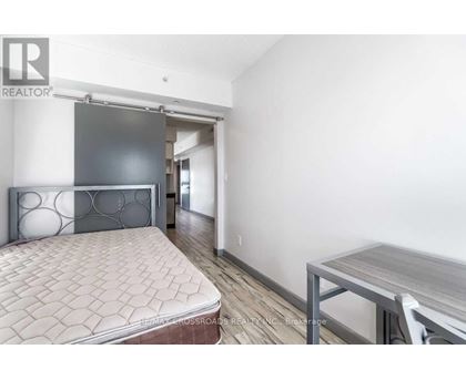 A bedroom with a bed, a table and a chair.
