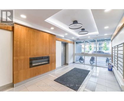 A modern interior space with a fireplace and a black rug on the floor.