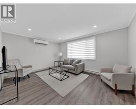 A living room with a white couch, a black chair, and a glass table.