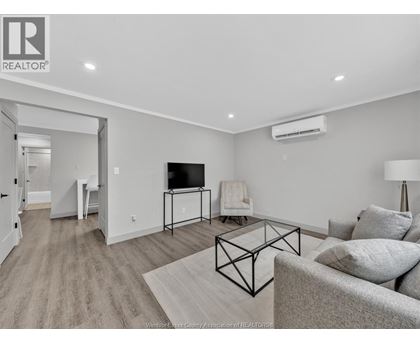 A living room with a grey couch and a black metal coffee table.