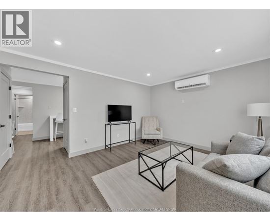 A living room with a grey couch and a black metal coffee table.