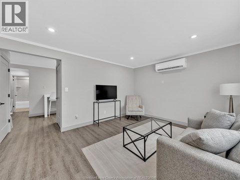 A living room with a grey couch and a black metal coffee table.