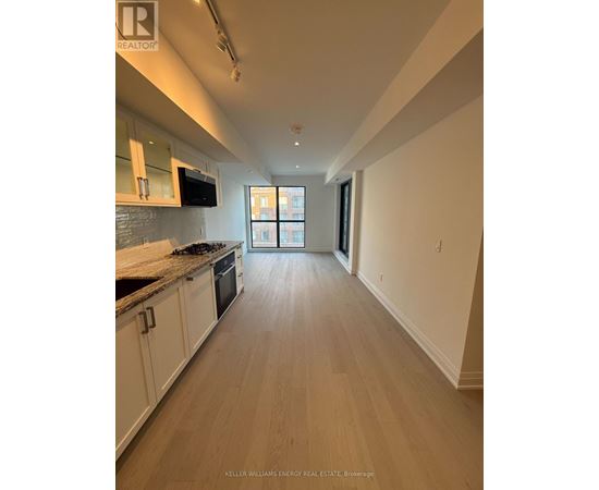 A kitchen with white cabinets and a black stove top oven.