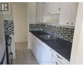 A kitchen with white cabinets and a black counter top.