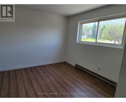 A room with a window and wooden flooring.