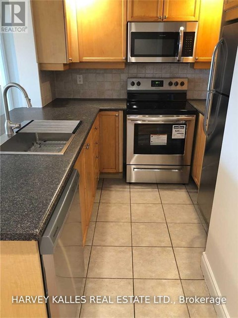 A kitchen with wooden cabinets and a black stove top oven.