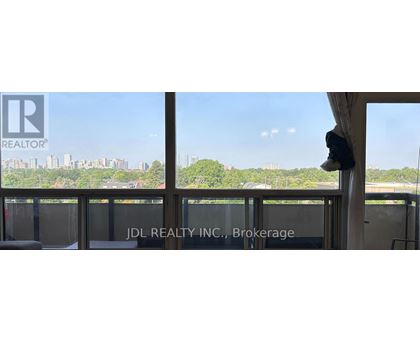 A window with a view of a city skyline and trees.