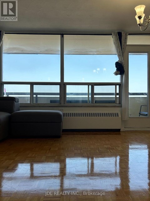 A living room with a couch and a large window overlooking the ocean.