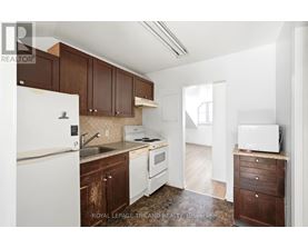 A kitchen with brown cabinets and white appliances.