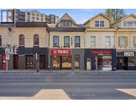 A street view of a row of buildings with shops on the ground floor.