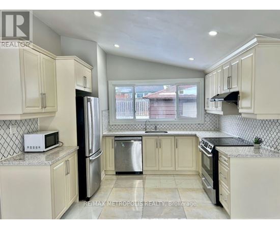A kitchen with white cabinets and a black refrigerator.