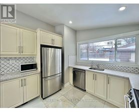 A kitchen with a refrigerator, microwave, and oven.