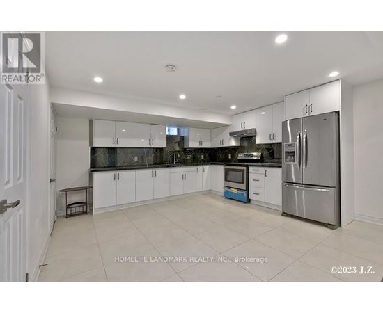 A modern kitchen with white cabinets and stainless steel appliances.