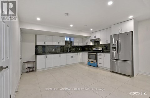 A modern kitchen with white cabinets and stainless steel appliances.
