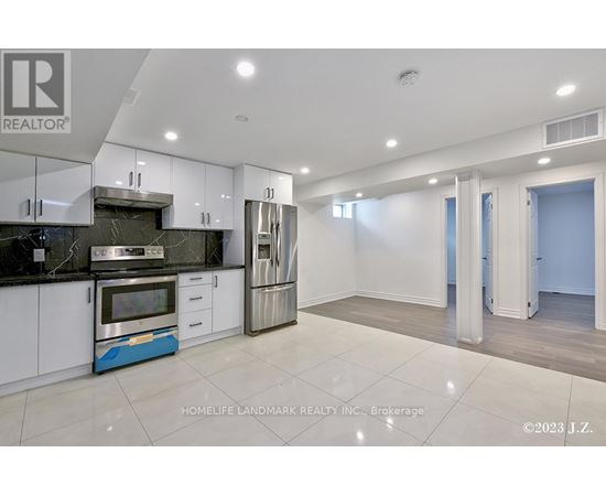 A modern kitchen with white cabinets and a blue accent on the island.