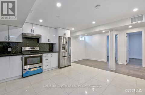 A modern kitchen with white cabinets and a blue accent on the island.