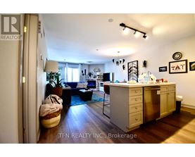 A well-lit kitchen with a dining table and chairs, and a Christmas tree in the background.