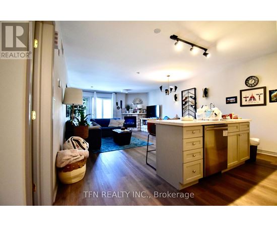A well-lit kitchen with a dining table and chairs, and a Christmas tree in the background.