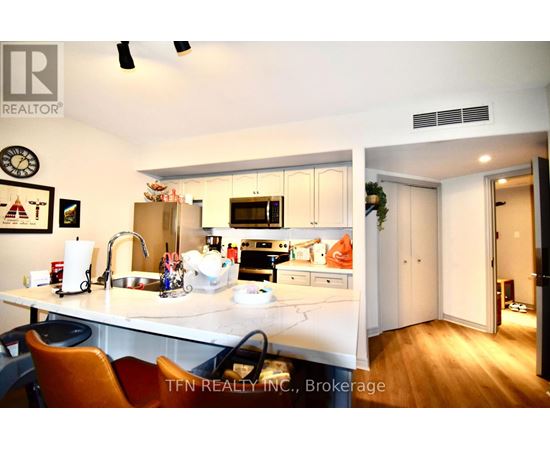 A kitchen with a sink, stove, and refrigerator.