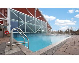 A pool area with a red building and a metal ladder.