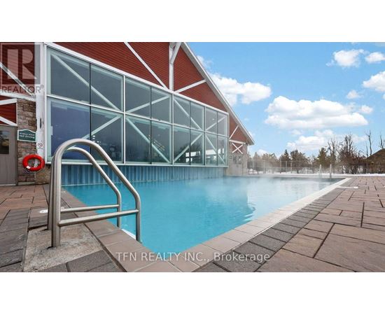 A pool area with a red building and a metal ladder.