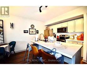 A kitchen with a white countertop and a dining table with chairs.