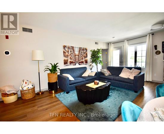 A living room with a blue couch and a wooden floor.