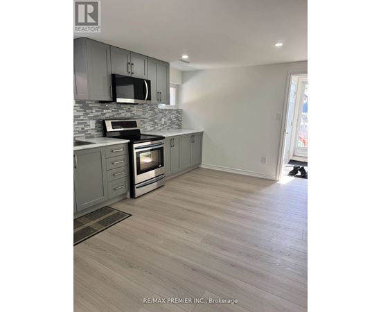 A kitchen with a grey cabinet and a black microwave.