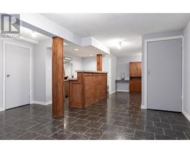 A spacious room with a wooden cabinet and a white door.