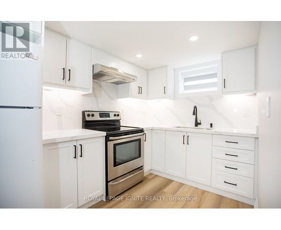A white kitchen with a stove, oven, and sink.