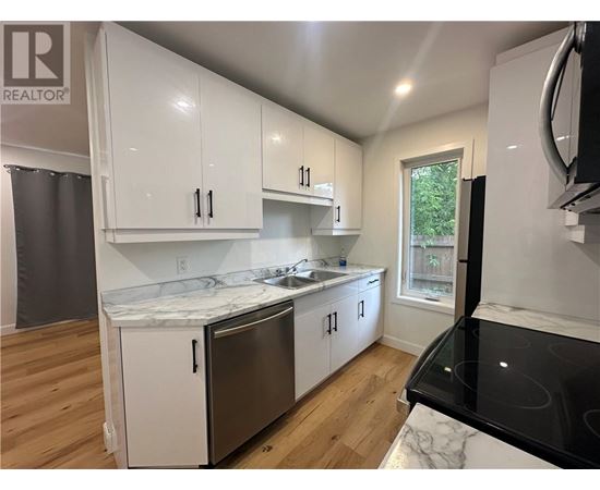 A kitchen with white cabinets and a black stove top.