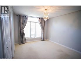 A bedroom with a large window and a chandelier.