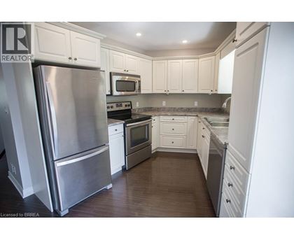 A kitchen with a stainless steel refrigerator and white cabinets.
