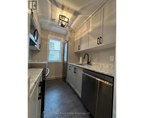 A kitchen with stainless steel appliances and white cabinets.