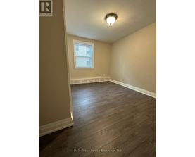A room with a window and wooden flooring.
