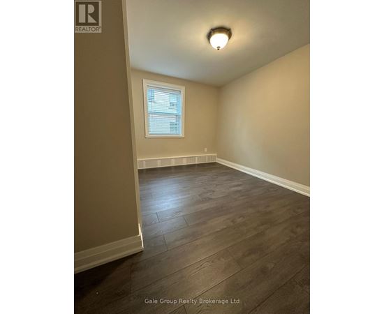 A room with a window and wooden flooring.