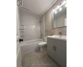 A bathroom with a white toilet, sink, and bathtub.