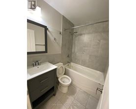 A bathroom with a toilet, sink, and bathtub.