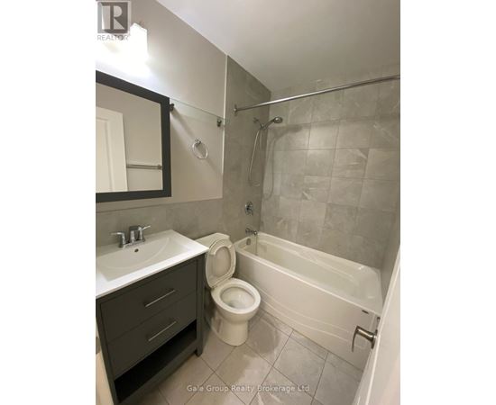 A bathroom with a toilet, sink, and bathtub.