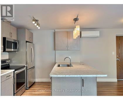 A spacious kitchen and living room with hardwood floors and a large window.