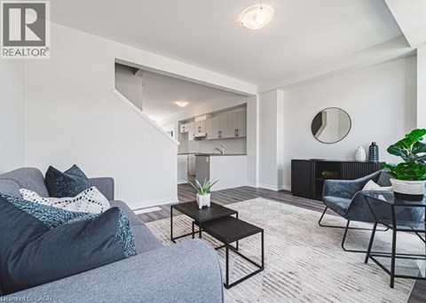 A living room with a grey couch, a black coffee table, and a grey armchair.