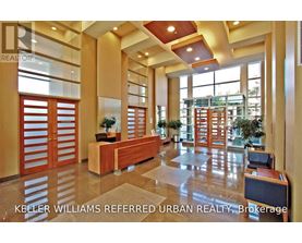 A lobby with a reception desk and a large window.
