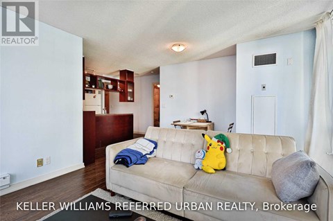 A living room with a couch and a small table with a lamp.