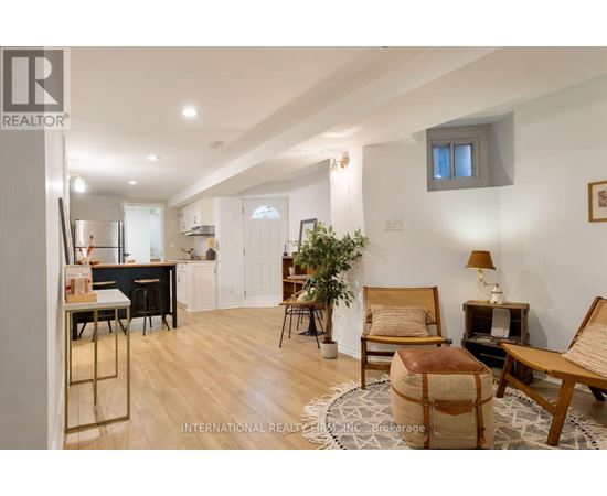 A well-lit, spacious living room with a dining area in the background.