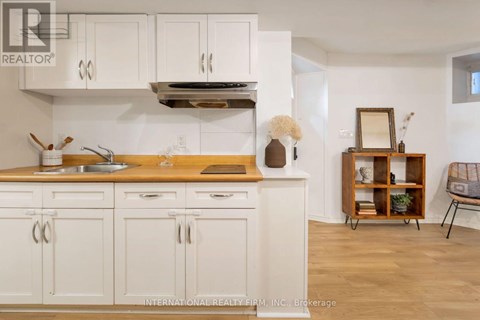 A kitchen with white cabinets and a wooden countertop.