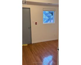 A room with a wooden floor and a window showing a staircase outside.