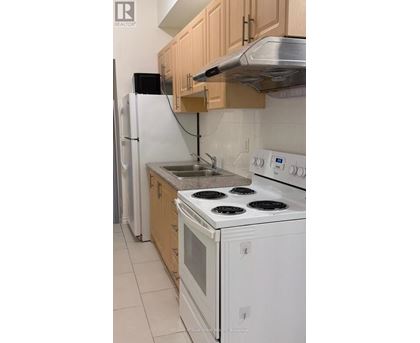 A kitchen with white appliances and wooden cabinets.