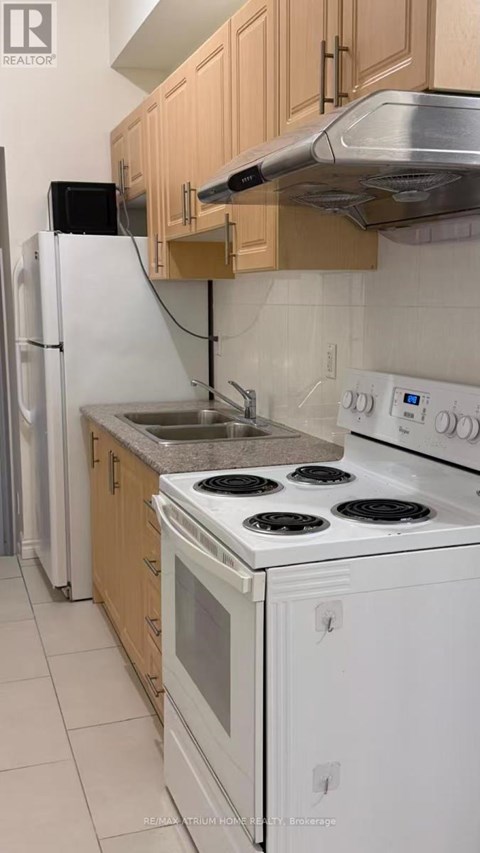 A kitchen with white appliances and wooden cabinets.